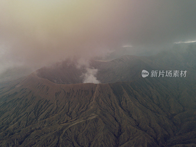 无人机鸟瞰图的Bromo火山口边缘与蒸汽在Bromo山国家公园在Cemoro Lawang村-东爪哇，印度尼西亚，亚洲。旅游目的地冒险的自然概念